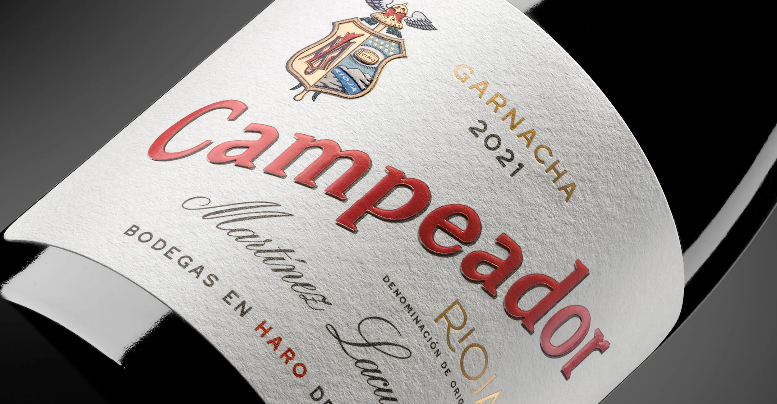 Detalle de la etiqueta de Campeador de Bodegas Martínez Lacuesta, con tipografía roja y negra sobre fondo blanco.