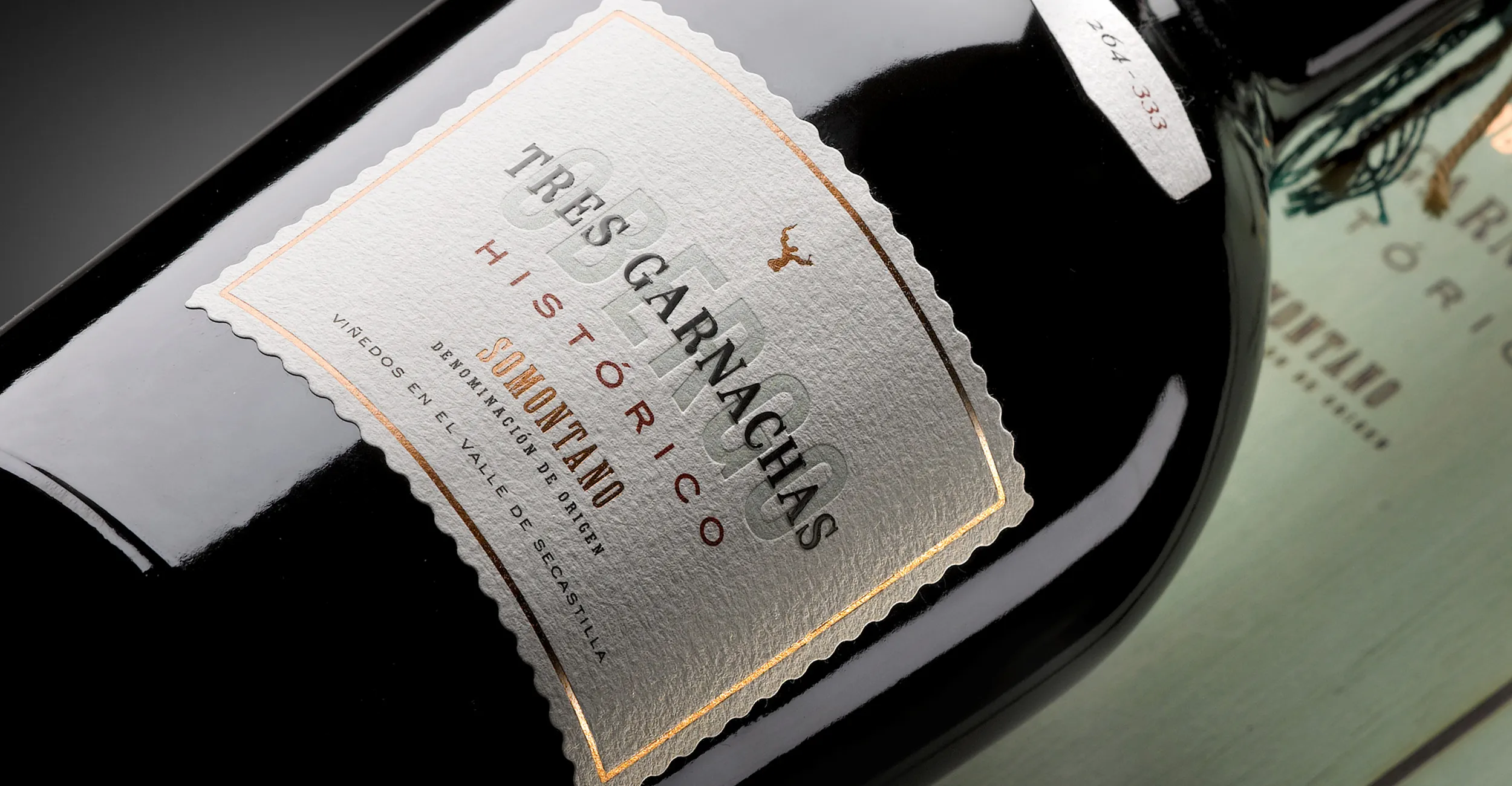 Etiqueta de Obergo Histórico Tres Garnachas de Bodegas Obergo, con tipografía clara sobre fondo crema.