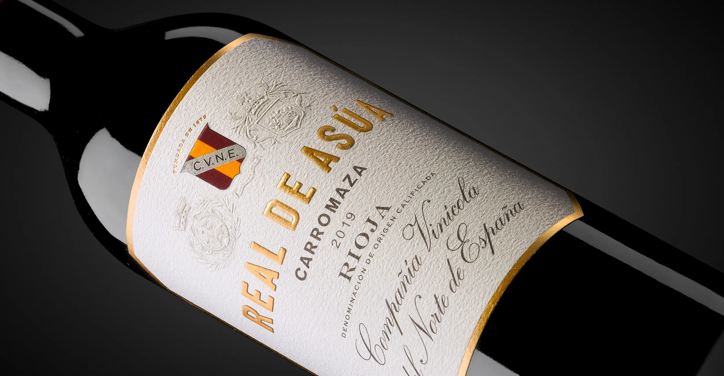 Etiqueta de Real de Asúa de CVNE, con los escudos de Haro, Bilbao y la bodega sobre fondo claro.